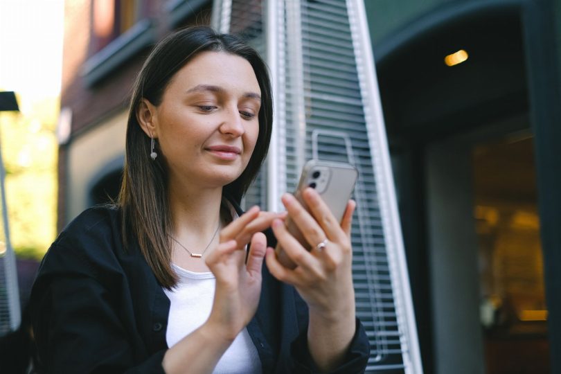 Pessoa segurando smartphone e selecionando estrelas em avaliação de empresa