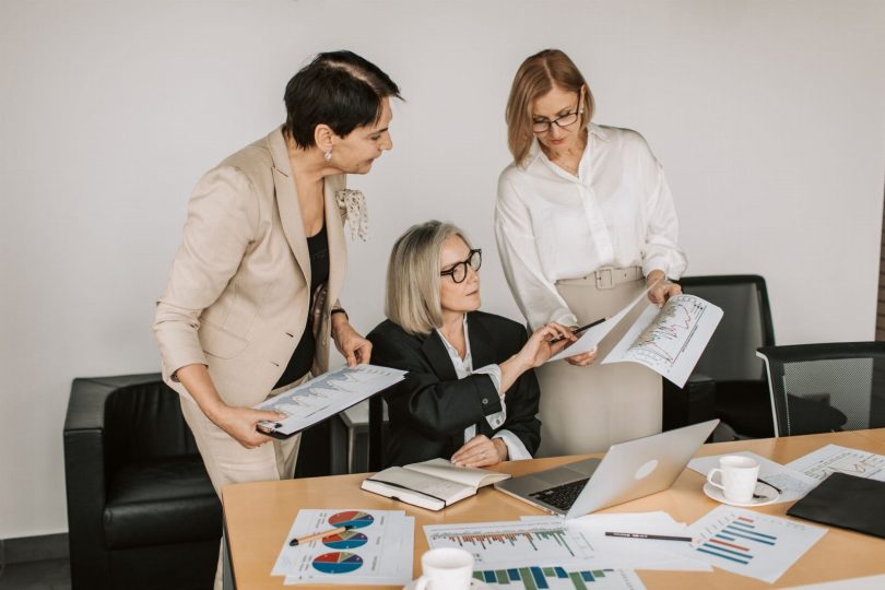 Equipe reunida analisando avaliações e métricas de reputação online em telas