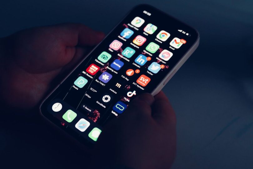 Pessoa consultando avaliações de clientes no smartphone e laptop